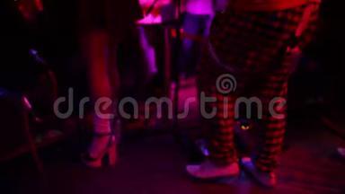 特写照片，年轻的时髦女人腿和红色吉他在霓虹灯。 <strong>摇滚音乐</strong>家在弹电吉他。